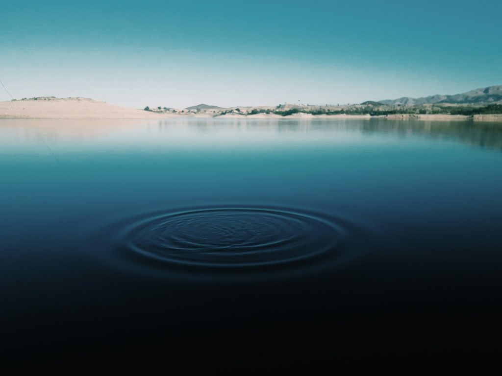 Circular ripples in calm water, representing how actions create lasting energy