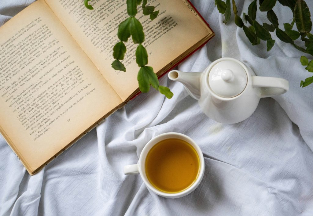 Cozy self-care moment with journal, cup of tea, and natural light