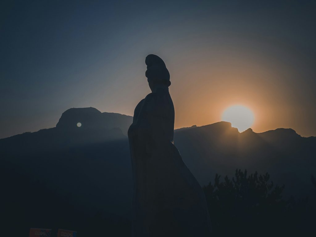 Silhouette of a woman at sunset on a mountain, reflecting peace and letting go