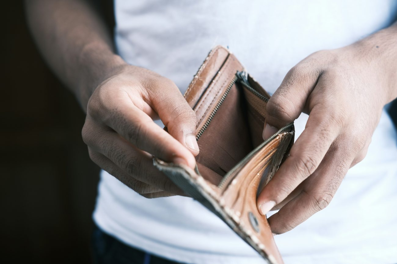 Being broke, Young woman checking empty wallet.