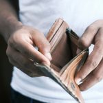 Being broke, Young woman checking empty wallet.